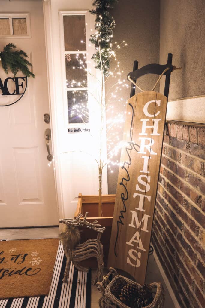 lighted birch trees and wooden sleigh sign