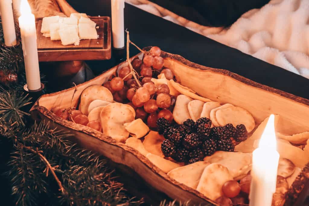 olive wood tray with food in it