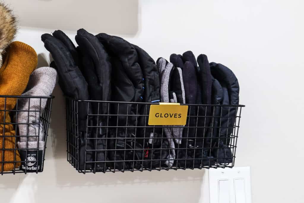 organize winter gloves in a wire basket with a label