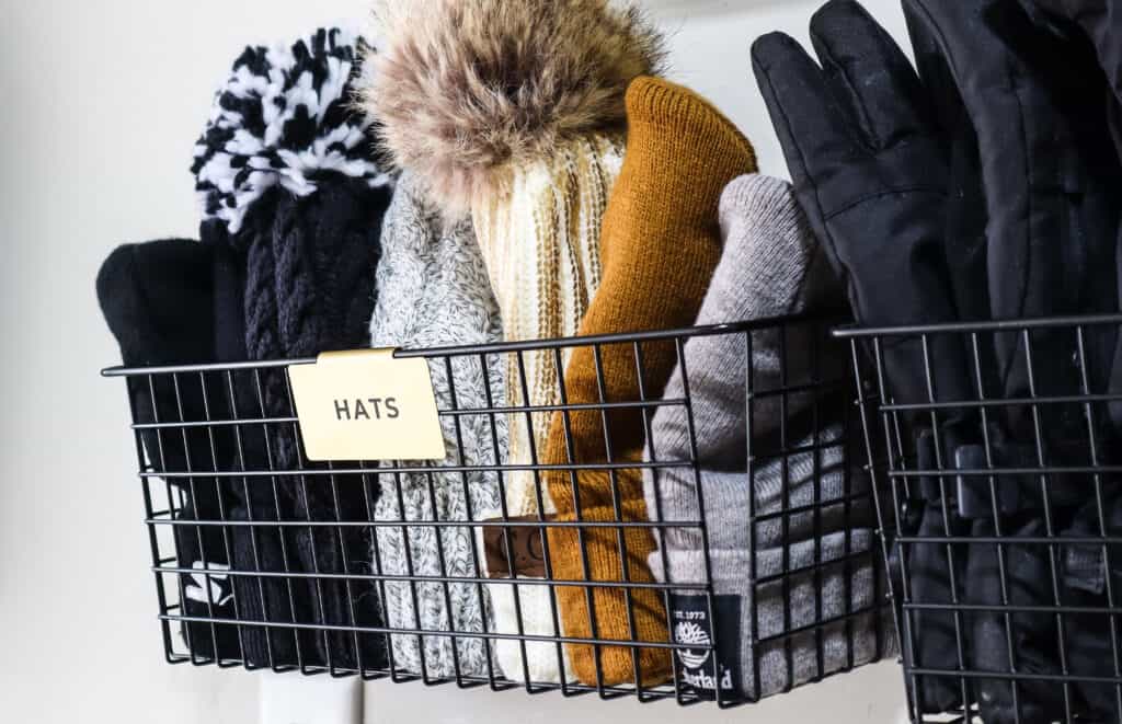 organized winter hats in baskets on a wall